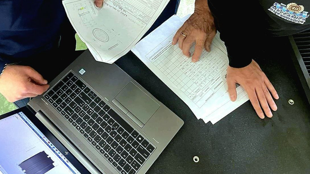 filosofia dimpresa 03 800×450 Tre persone che lavorano con disegni e computer